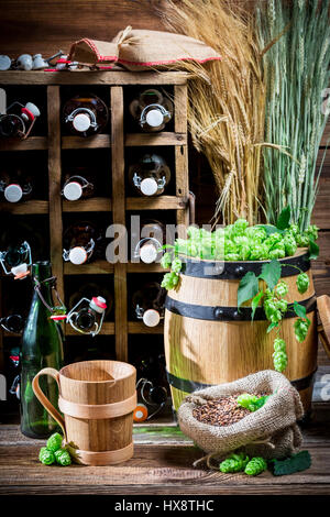 Gourmet cantina di birra pieno di bottiglie sul vecchio tavolo in legno Foto Stock