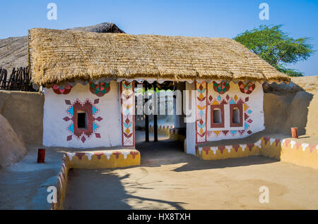 KUTCH, INDIA - dicembre. 27 2016: esterno di un ingresso di decorazione della casa costruita con paglia e fango e pietra a villaggio nel Kutch, Gujarat, India Foto Stock