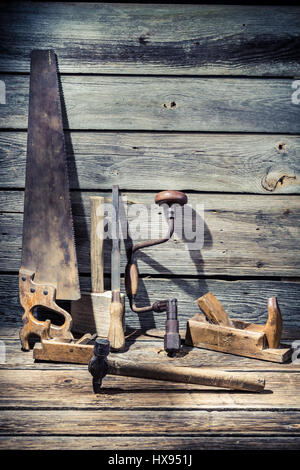Martello, sega e scalpello sul vecchio tavolo in legno Foto Stock