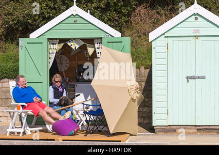 Bournemouth Dorset, Regno Unito. 26 Mar, 2017. Regno Unito: meteo bella calda giornata di sole come testa di visitatori al mare per rendere la maggior parte del sole a Bournemouth spiagge. Giovane godendo il sole e rilassarsi presso il beach hut con cane Credito: Carolyn Jenkins/Alamy Live News Foto Stock