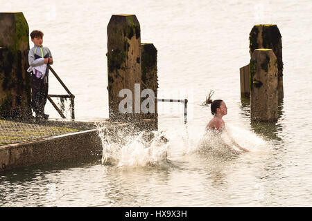 Aberystwyth, Wales UK, madri giorno, domenica 26 marzo 2017 UK meteo: Kids il salto in mare al largo del molo di legno in un caldo pomeriggio in una giornata di sole e cielo azzurro in Aberystwyth sulla West Wales coast. Photo credit: keith morris/Alamy Live News Foto Stock