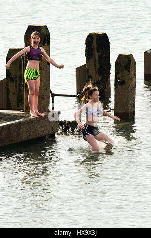 Aberystwyth, Wales UK, madri giorno, domenica 26 marzo 2017 UK meteo: Kids il salto in mare al largo del molo di legno in un caldo pomeriggio in una giornata di sole e cielo azzurro in Aberystwyth sulla West Wales coast. Photo credit: keith morris/Alamy Live News Foto Stock