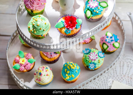 Gustosi muffin con decorazione dolce sul vecchio tavolo bianco Foto Stock