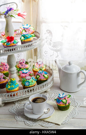 Gustosi tortini con decorazione dolce sul vecchio tavolo bianco Foto Stock