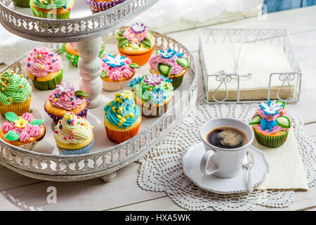 Deliziosi muffin con decorazione dolce sul vecchio tavolo bianco Foto Stock