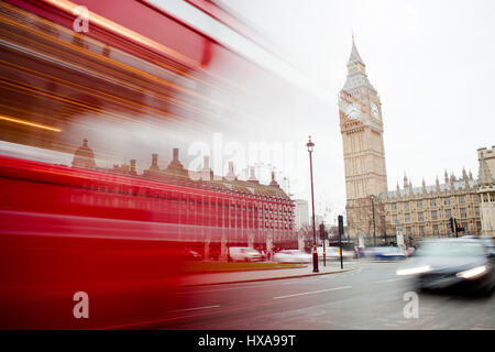 Red Bus londinese passando nel centro città con il Big Ben in background Foto Stock