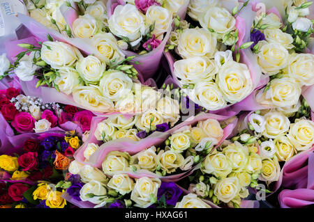 I grappoli di diverse colorate di rose in vendita e sul visualizzatore in corrispondenza di un fioraio. Foto Stock