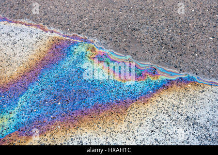 Color arcobaleno fuoriuscite di olio su asfalto bagnato la superficie stradale Foto Stock