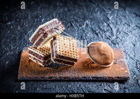 Fette di dolce con noci e cioccolato sulla lastra di pietra Foto Stock