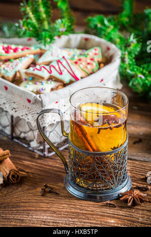 Orange tè con cannella e chiodi di garofano sul vecchio tavolo in legno Foto Stock