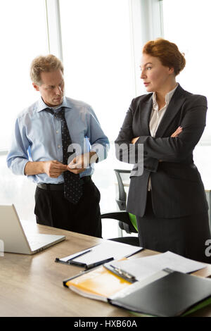 Due borchie arrabbiato l uomo e la donna in ufficio Foto Stock