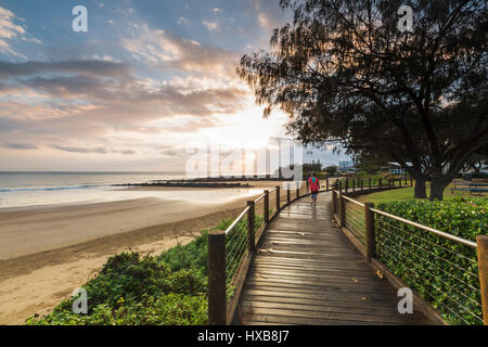 La mattina presto walker sull'Esplanade Boardwalk a Bargara Beach, a Bundaberg, Queensland, Australia Foto Stock