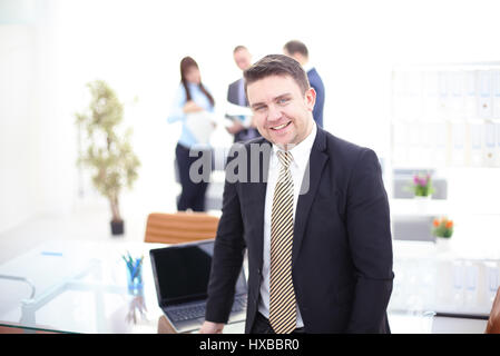 Il successo del team leader e business leader proprietario riunione informale in-house business meeting. Imprenditore lavorando sul computer portatile in primo piano. Business e entrep Foto Stock