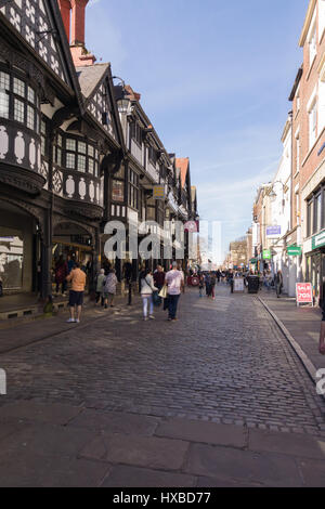 Gli acquirenti di Chester e i visitatori su Northgate Street con i suoi ciottoli pavimenti di pietra e bellissima mezza edifici con travi di legno Foto Stock