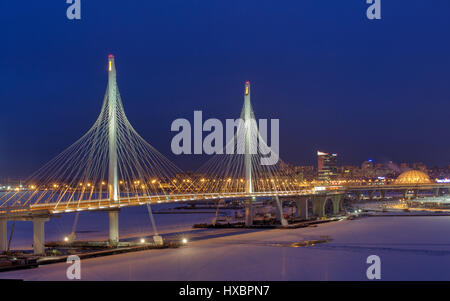 San Pietroburgo, Russia - 3 Gennaio 2017: strade Express attraversa il fiume icebound, ponte controventato a illuminazione notturna in inverno. Foto Stock