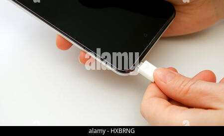 Mano femmina collegando il caricabatterie del telefono cellulare smartphone Foto Stock