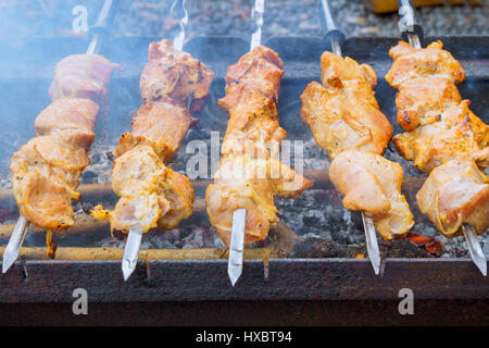 Primo piano di alcuni spiedini di carne alla griglia essendo in un barbecue Foto Stock