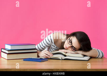 Esaurito studente a dormire la sua scrivania Foto Stock