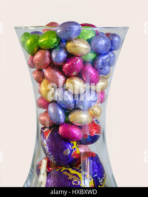 Mini uova di pasqua di cioccolato avvolto in Colorati luminosamente involucri di carta metallizzata in un vaso di vetro. Foto Stock