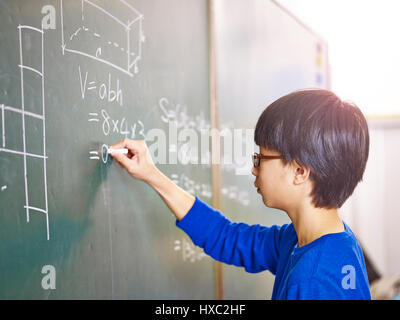 Asian grade school studente per risolvere un problema di geometria sulla lavagna in classe math. Foto Stock