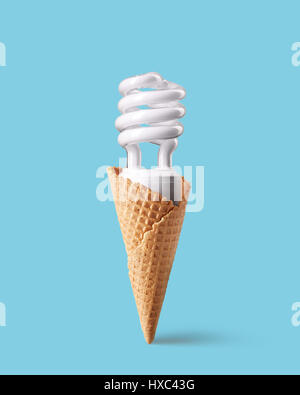 Compatta lampadina fluorescente in cono gelato su sfondo blu. Gelati preparati con lampadina a risparmio energetico. Concetto innovativo. Foto Stock