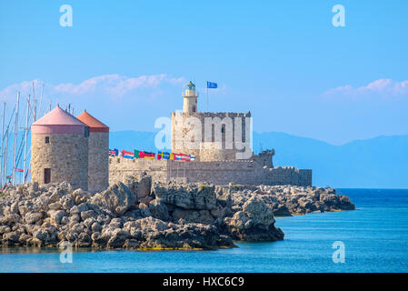 Vecchio Agios Nikolaos Fortezza, Faro e mulini a vento in Mandraki Harbour. Rhodes, isole Dodecanesi, Grecia Foto Stock