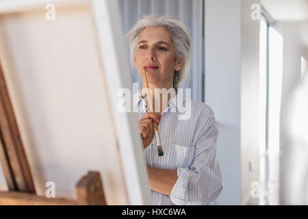 Malinconici donna matura la pittura di cavalletto Foto Stock