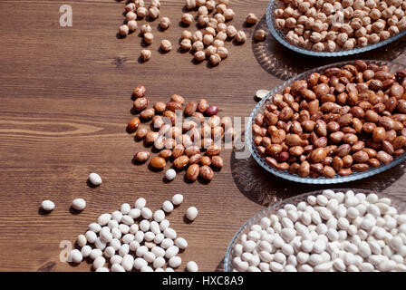Impulsi in una ciotola su una tavola di legno per bacgrounds (fagioli, fave di fagioli e ceci) Foto Stock