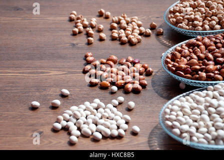 Impulsi in una ciotola su una tavola di legno per bacgrounds (fagioli, fave di fagioli e ceci) Foto Stock