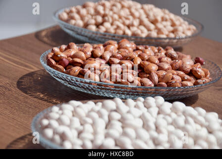 Impulsi in una ciotola su una tavola di legno per bacgrounds (fagioli, fave di fagioli e ceci) Foto Stock