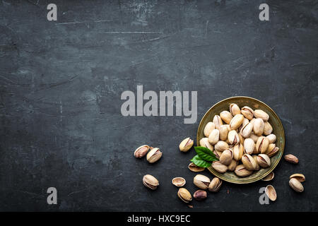 Pistacchi Noci su sfondo scuro, vista dall'alto, snack sani Foto Stock