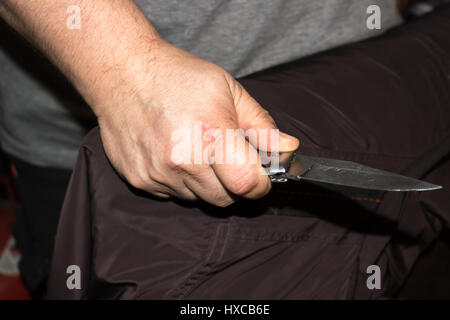 Primo piano di un giovane uomo di mano, tenendo un coltello, per attaccare, Foto Stock