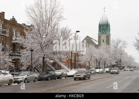 Montreal, Canada - 25 Marzo 2017: Christophe-Colomb Street e Paroisse Saint-Arsene chiesa in inverno Foto Stock