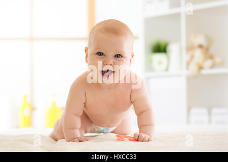 Gioiosa baby strisciando sul pavimento nella nursery room Foto Stock