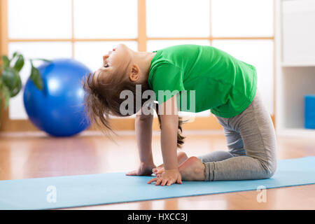 Bambino ragazza di eseguire la rana execrcise sportive in palestra Foto Stock