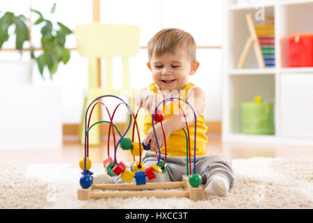 Kid boy gioca con il giocattolo educativo in ambienti interni Foto Stock