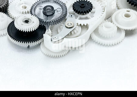 Bianco e nero gli ingranaggi in plastica sul metallo graffiato background industriale Foto Stock