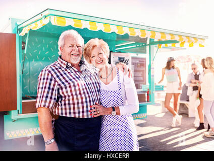 Ritratto sorridente senior business proprietari al di fuori di sunny food cart Foto Stock