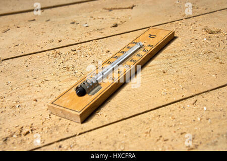 Un termometro giace su un pavimento di legno nel mazzo, un termometro è su un pavimento di legno copertura in |, Ein termometro liegt auf einen Holzfußboden im D Foto Stock