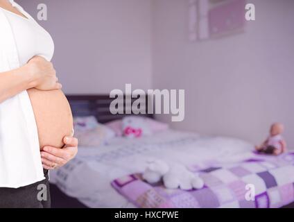 Digital composito della donna incinta metà sezione azienda stomaco in camera da letto sfocate con sovrapposizione di colore rosa Foto Stock