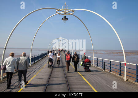 Famiglie che camminano sul molo a Southport, Merseyside. Meteo Regno Unito. 27th marzo 2017. Sole mozzafiato sulla spiaggia e sul molo per i passeggini che si godono una brillante giornata di primavera nel resort. Credit: MediaWorldImages/AlamyLiveNews Foto Stock