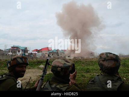 Srinagar Kashmir. 28 Mar, 2017. Esercito indiano tenendo la posizione durante il funzionamento come polvere e fumo flutti fuori da una casa residenziale che è stato soffiato durante uno scontro a fuoco tra i miliziani e i soldati indiani in Durbagh villaggio di Chadoora, 15 km da Srinagar. Tre civili e un militante sono stati uccisi e un Indiano soldato ferito durante una 10-ora-lunga gunfight. Credito: sofi suhail/Alamy Live News Foto Stock