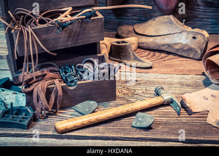 Vintage cobbler workplace con scarpe, lacci e strumenti Foto Stock