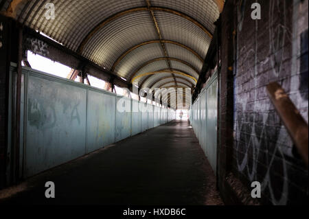 La corsa verso il basso il Footbridge sopra le piattaforme e le vie a Hove Railway pubblico passeggio su Hove Stazione ferroviaria linea Brighton SUSSEX REGNO UNITO Foto Stock
