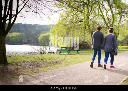 Couple walking and holding hands on sunny spring afternoon in Westport lake area near Stoke on Trent,Staffordshire,UK,26 March,2017. Foto Stock
