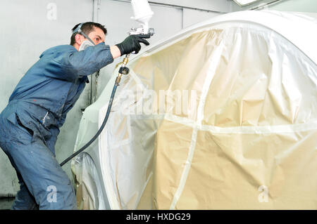 Lavoratore dipinto bianco auto. Foto Stock