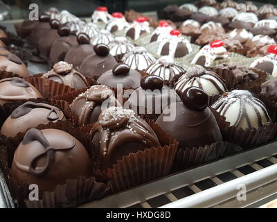 Un assortimento di tartufi di cioccolato Dessert allineate in un panificio display Foto Stock