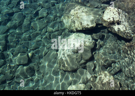Vista superiore della superficie del mare con scogli al mare vicino al centro cittadino di Bodrum in Turchia. Foto Stock