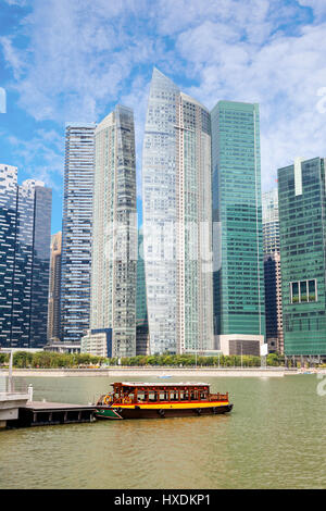 Un dock sulla bumboat presso il Marina Bay con grattacieli in Singapore business district in background. Foto Stock