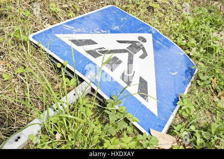 Sul terreno recumbent segno su un crosswalk, un attraversamento pedonale segno giacente a terra |, Auf den Boden liegendes Hinweisschild auf einem Fußgäng Foto Stock